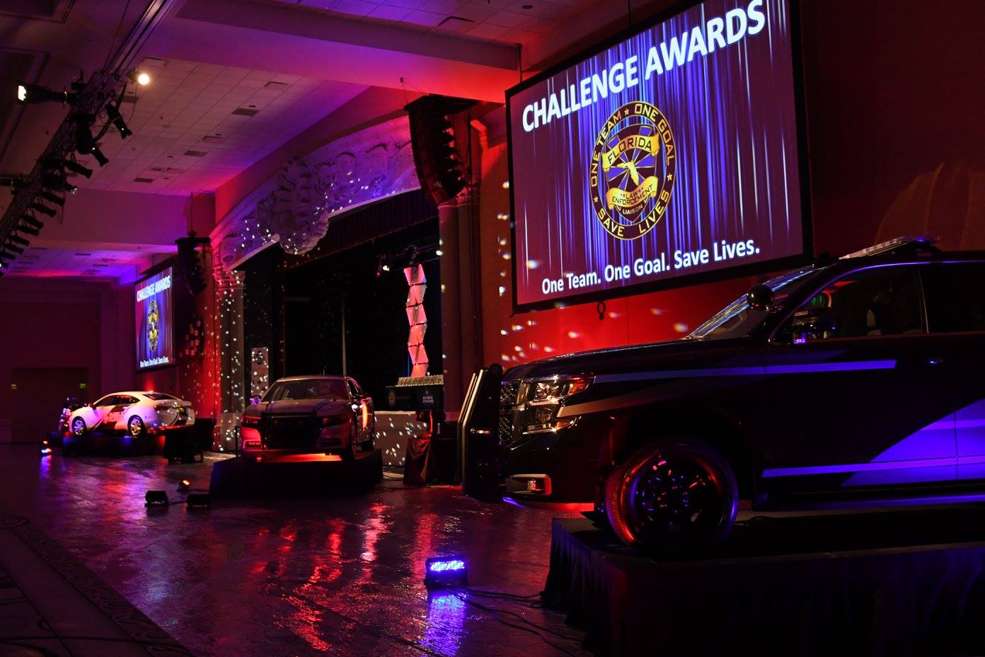 Challenge Awards stage with patrol vehicles and 'One Team. One Goal. Save Lives.' screen