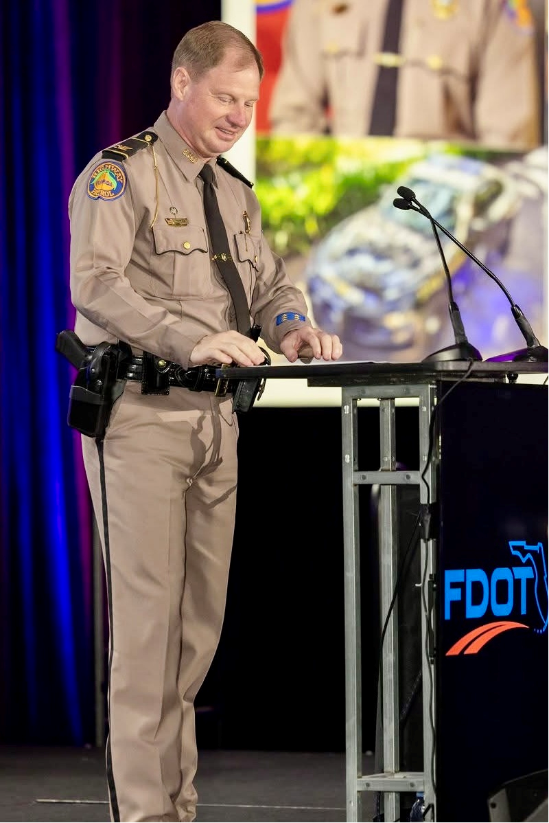 Florida Highway Patrol officer speaking at the FDOT podium during the Recognition Event